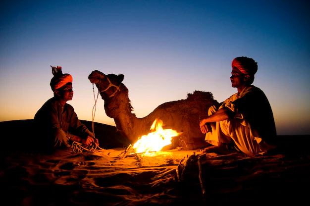 indian-men-resting-by-bonfire-with-their-camel_53876-47057 (1)