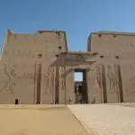 The image depicts the Temple of Edfu, a Ptolemaic temple dedicated to the falcon god Horus located on the west bank of the Nile River in Edfu, Egypt. Construction began on the temple in 237 BC and it was not completed until 57 BC. The temple is known for its well-preserved hieroglyphs and reliefs.