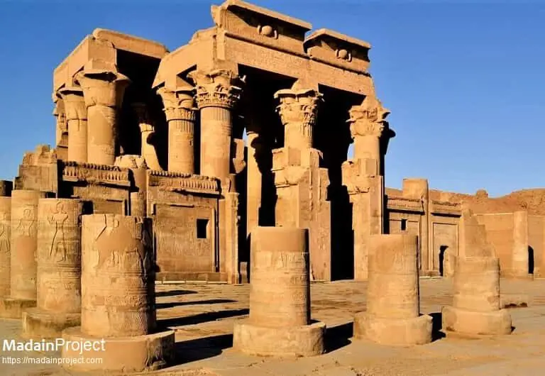 A photo of the Temple of Kom Ombo at night, an ancient Egyptian temple with tall columns illuminated against a starry sky.